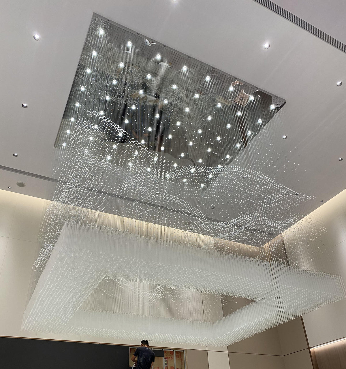Crystal rainfall curtain chandelier with mirrored canopy in a double-height atrium