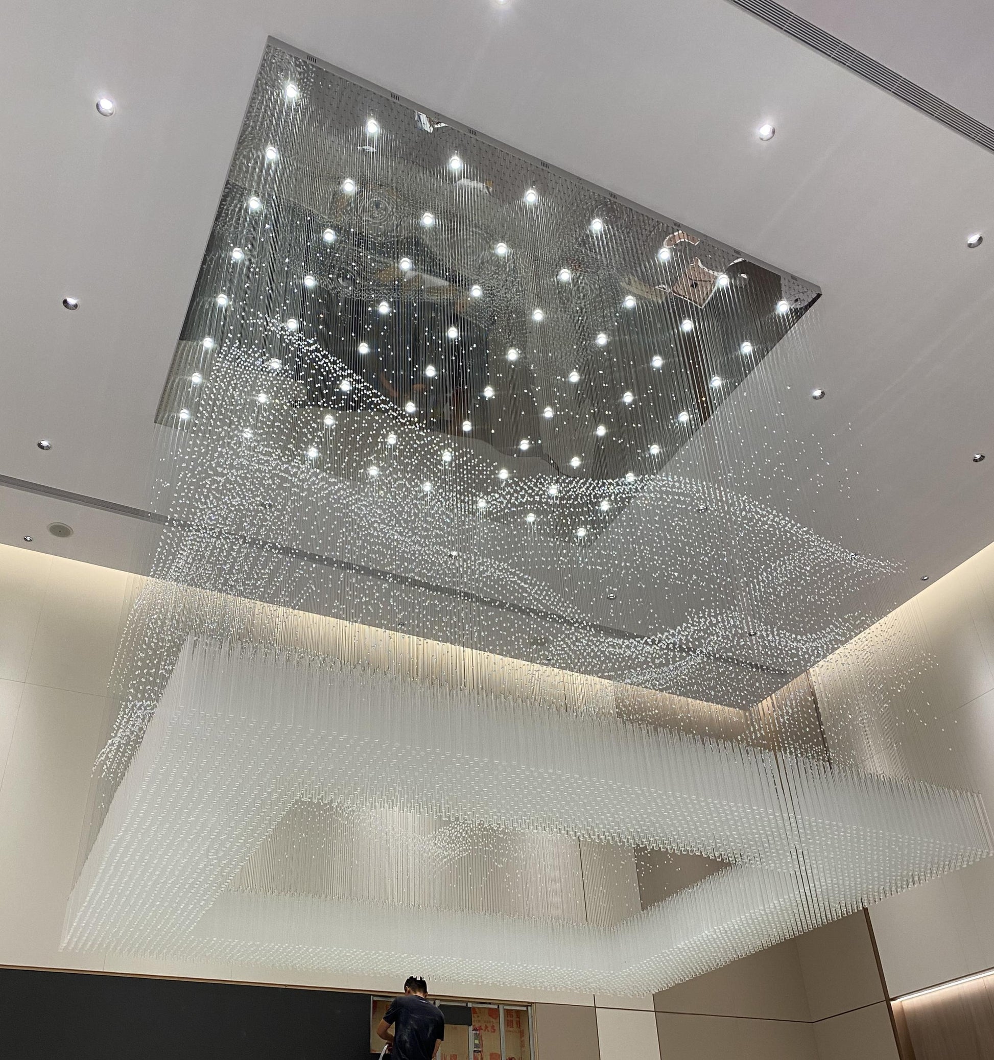 Crystal rainfall curtain chandelier with mirrored canopy in a double-height atrium