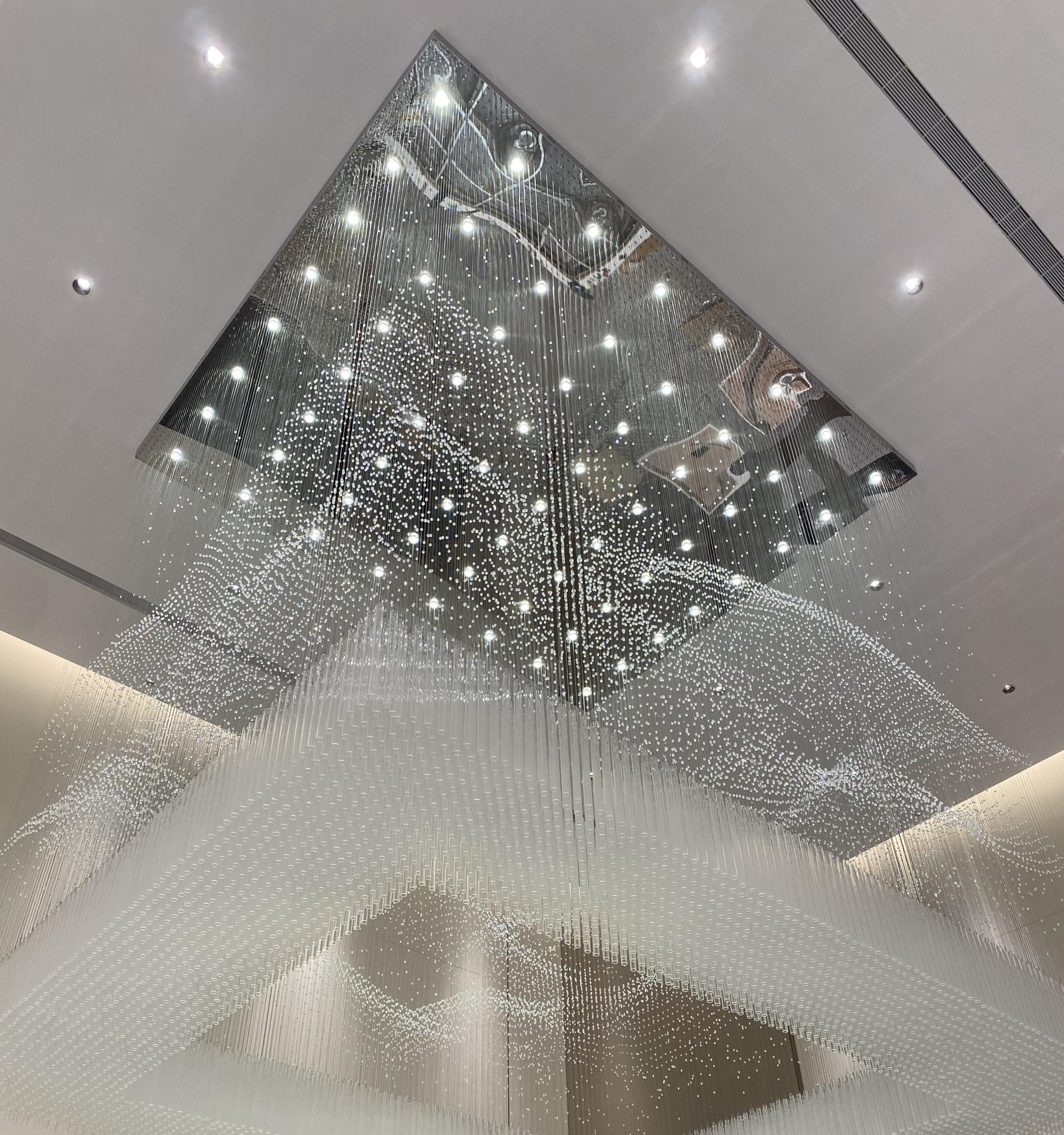 Wave-contoured crystal strand drop of the rainfall curtain chandelier