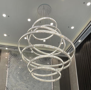 Spiral tiered crystal ring chandelier suspended in a double-height foyer