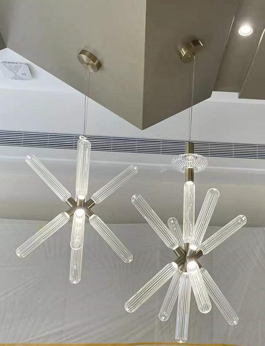 Starburst glass rod chandelier pair with ribbed glass rods radiating from a brass hub