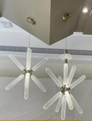 Starburst glass rod chandelier pair with ribbed glass rods radiating from a brass hub