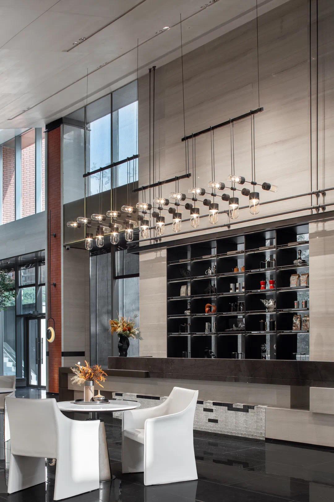 Cascading glass cylinder chandelier with staggered pendant drops above a reception lounge counter