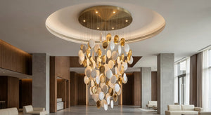 Pearl White & Gold Disc Cascade Chandelier - a custom cylindrical disc chandelier in a double-height lobby