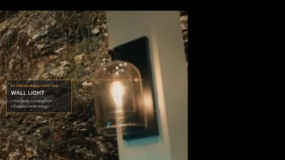Exposed-bulb wall light on the resort’s feature stone wall