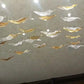 Glass leaves drifting across the ceiling in a flowing band