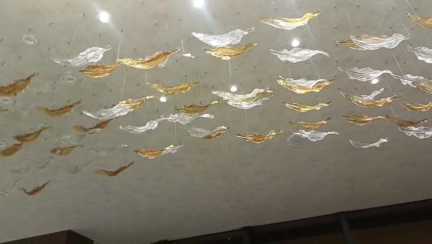 Glass leaves drifting across the ceiling in a flowing band