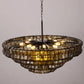 Angled underside view revealing the radial metal frame and warm glowing bulbs inside the wavy smoked glass tiers