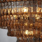 Macro close-up of the hammered texture and undulating S-curve profile of the smoked amber glass ribbons