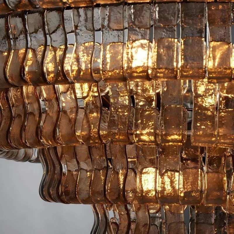 Macro close-up of the hammered texture and undulating S-curve profile of the smoked amber glass ribbons